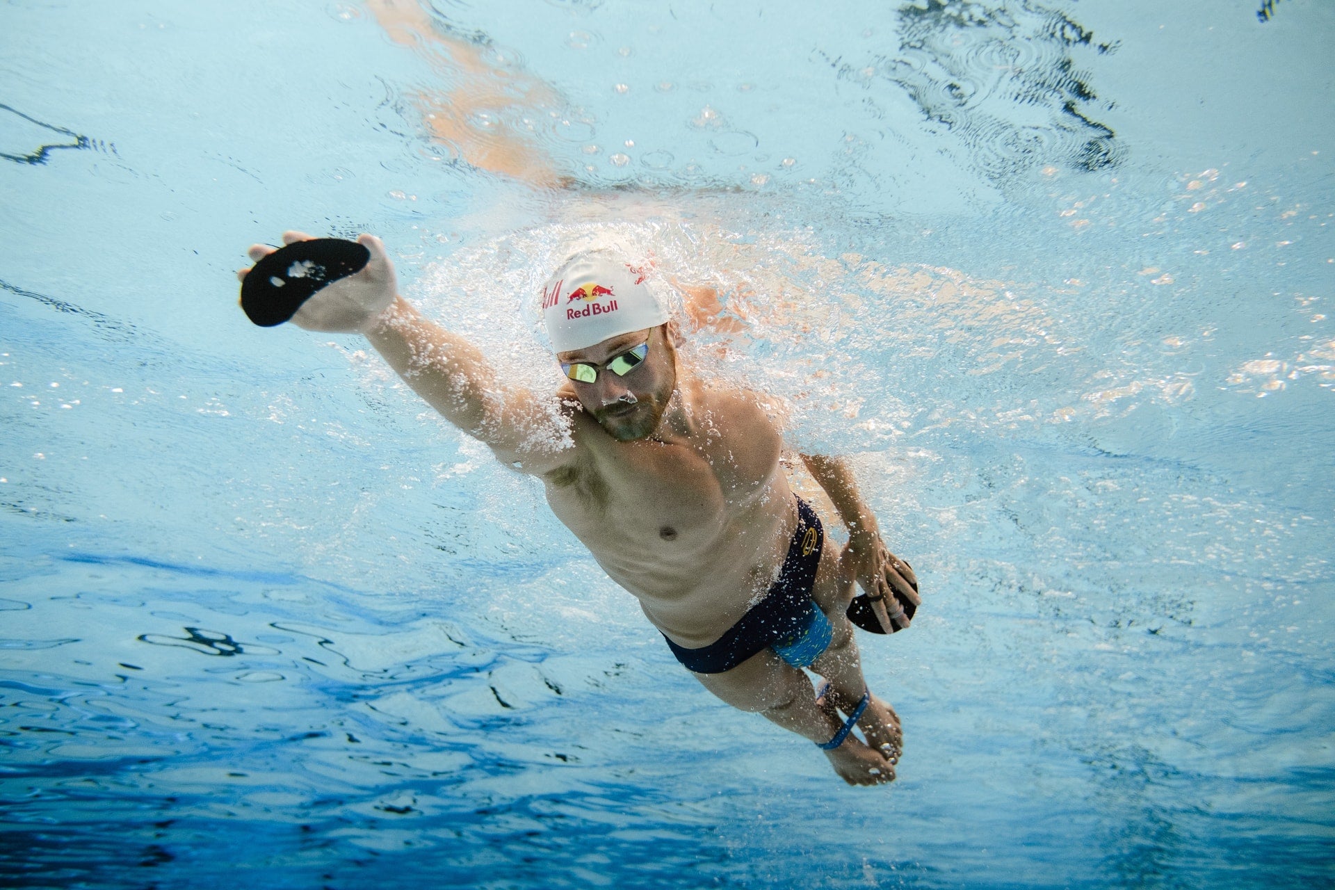 daniel bækkegård svømmer i en pool med finger paddles