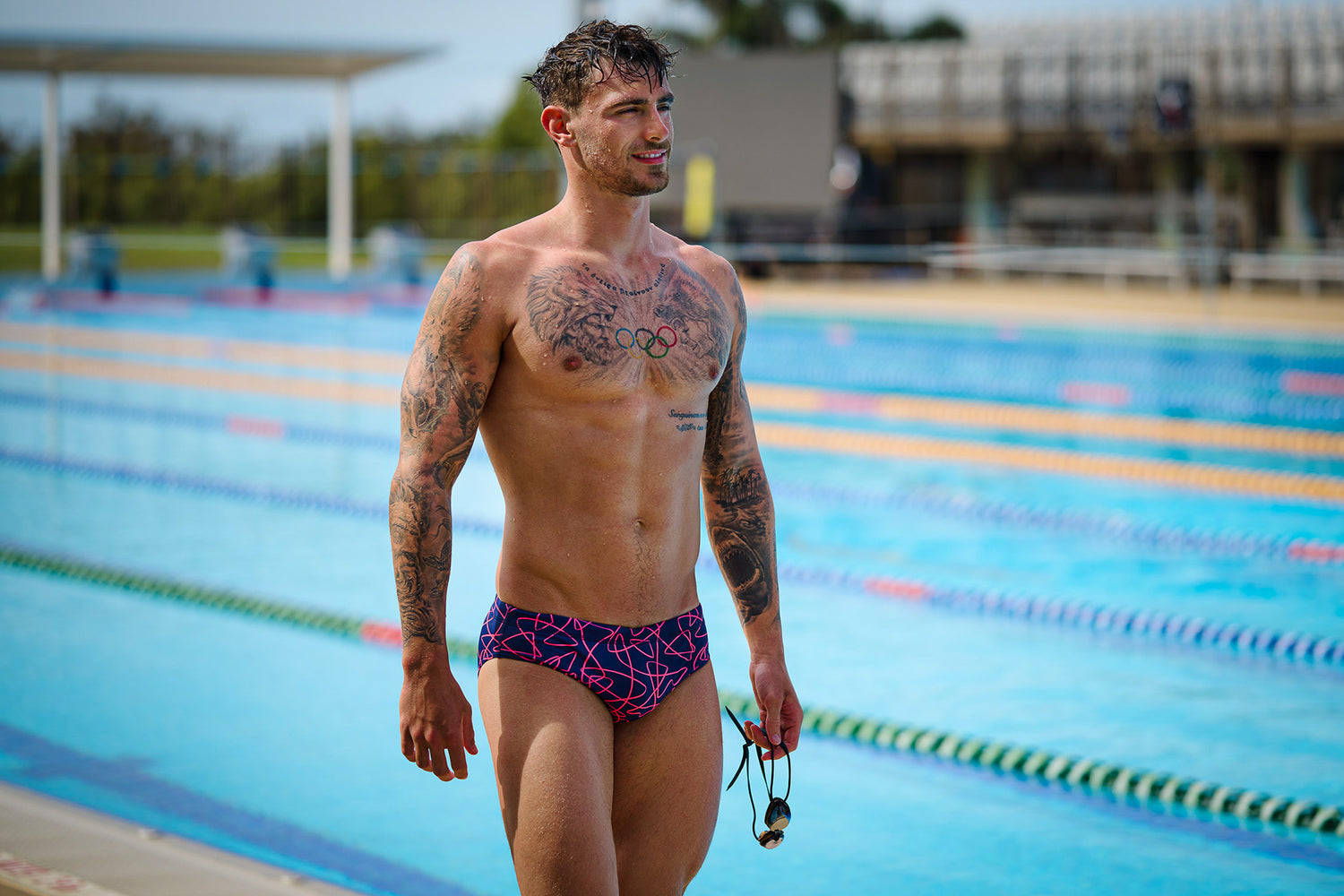 mand står ved siden af poolen i funky trunks